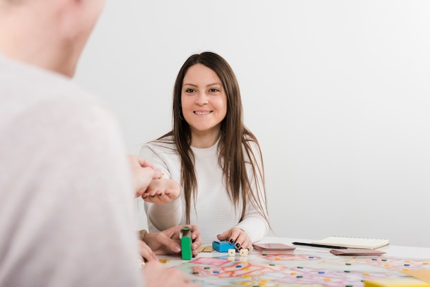 Vooraanzicht glimlachende vrouw die een raadsspel speelt