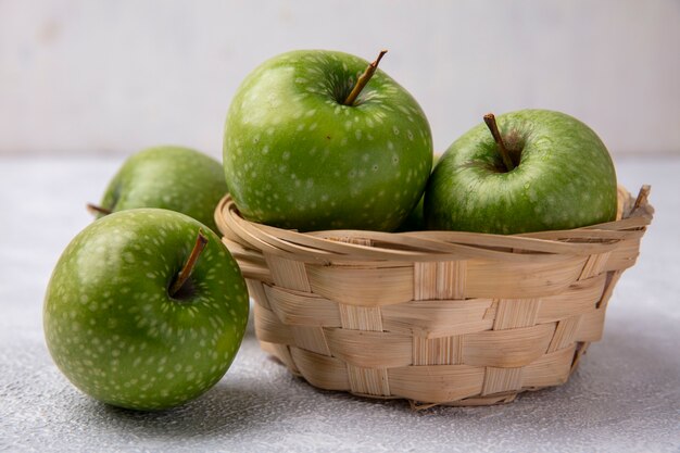 Vooraanzicht groene appels in een mand op een witte achtergrond