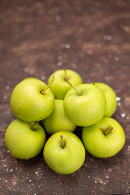 Vooraanzicht groene appels zacht en sappig geïsoleerd op bruin