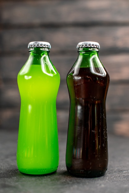Vooraanzicht groene en zwarte limonade in flessen