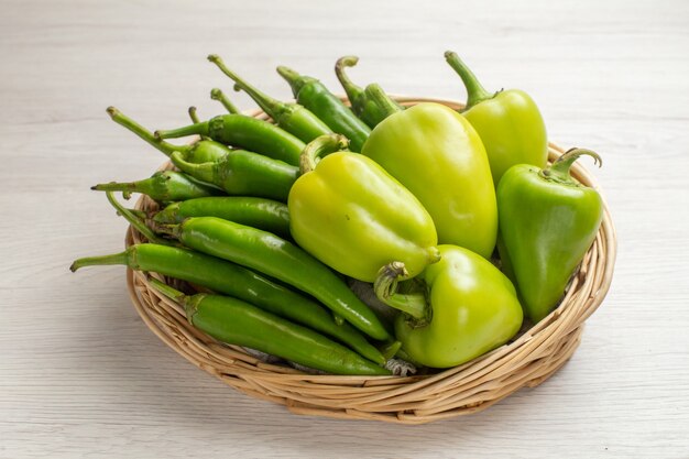 Vooraanzicht groene pittige pepers met paprika in mand op witte achtergrondkleur hete edgy groentesalade foto rijp