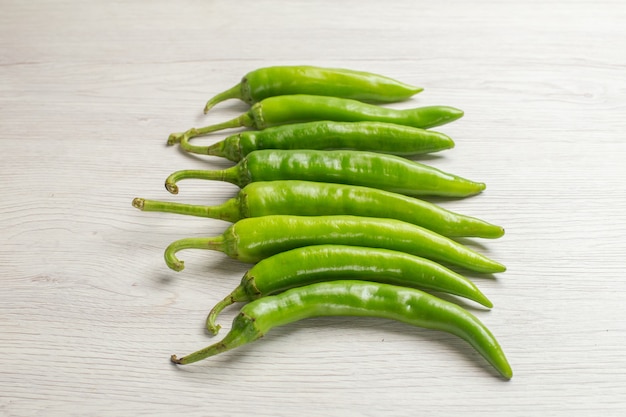 Vooraanzicht groene pittige pepers op witte achtergrond hete edgy rijpe salade kleurenfoto