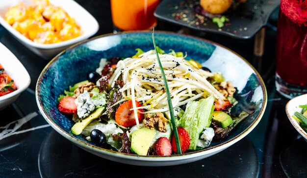 Vooraanzicht groente salade met fruit aardbeien en druiven in een plaat