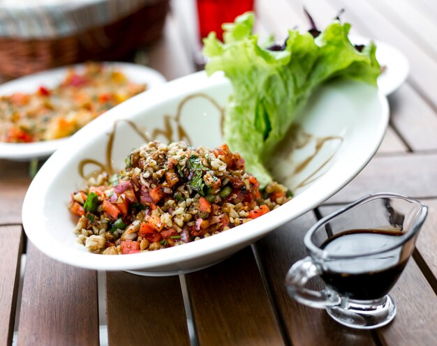 Vooraanzicht groente salade met walnoot en granaatappelsaus op tafel