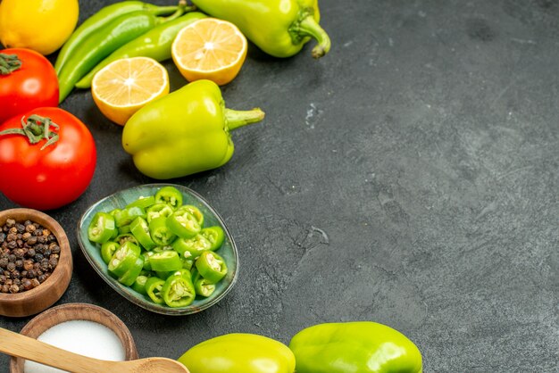 Vooraanzicht groenten samenstelling tomaten paprika en citroen op een donkere achtergrond maaltijdsalade gezondheidsdieet voedsel