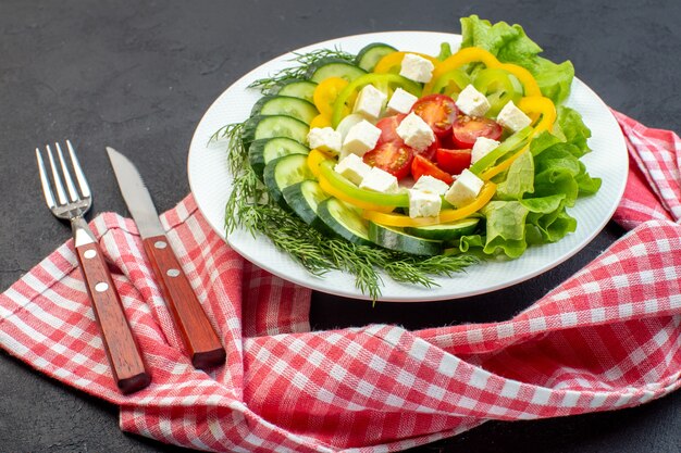 vooraanzicht groentesalade bestaat uit gesneden tomaten, komkommers, peper en kaas op een donkere achtergrond