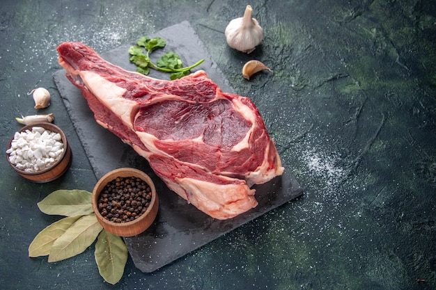Vooraanzicht groot vlees plak rauw vlees met peper op donkere diermeel foto kip eten barbecue slager