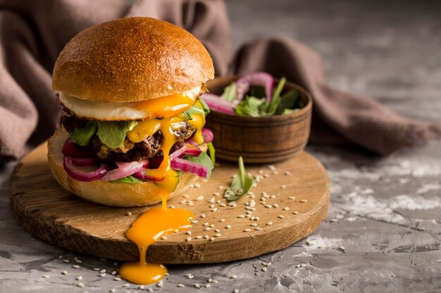 Vooraanzicht hamburger met gebakken ei op snijplank