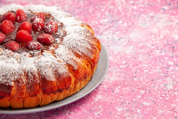 Vooraanzicht heerlijke aardbeientaart gebakken met suikerpoeder op lichtroze oppervlakte cake zoete suiker biscuit koekjes taart