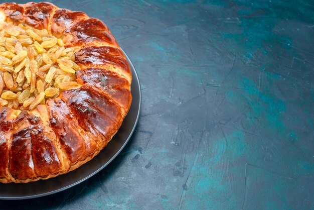 Vooraanzicht heerlijke cake ronde gevormd zoet met rozijnen op lichtblauwe achtergrond.