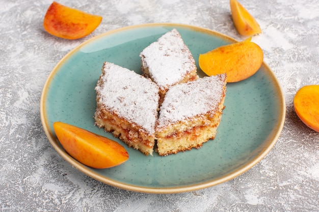 Vooraanzicht heerlijke cakeplakken met suikerpoeder en verse perziken in plaat op tafel, cake, koekjes, suiker, zoet gebak bakken