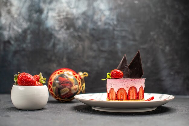 Vooraanzicht heerlijke cheesecake met aardbei en chocolade op ovale plaatkom aardbeien
