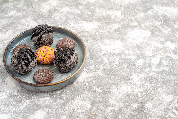 Vooraanzicht heerlijke chocolade ballen taarten met koekjes op een lichte witte ruimte