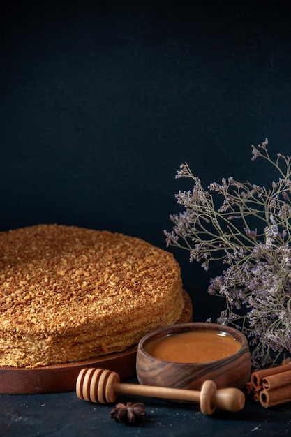 Vooraanzicht heerlijke honingcake op de donkere achtergrond deeg suiker dessert taart taart koekje thee biscuit zoete bak