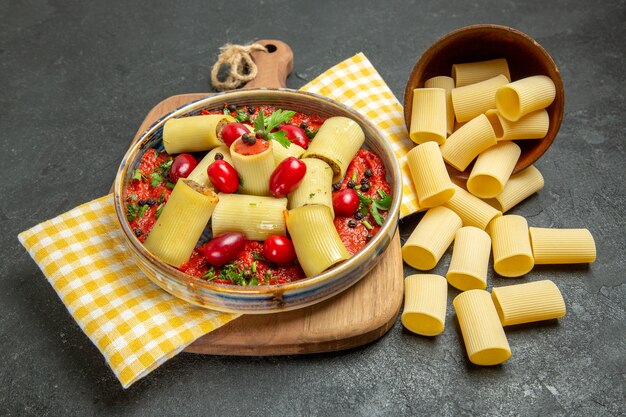 Vooraanzicht heerlijke Italiaanse deegwaren met vlees en tomatensaus op het grijze voedsel van het het dinerdeeg van achtergrondmaaltijddeegwaren