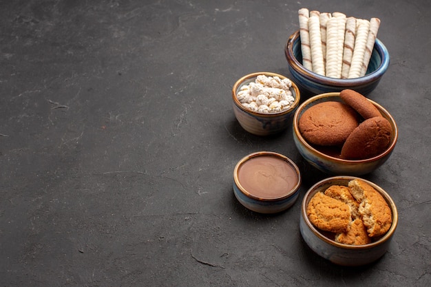 Vooraanzicht heerlijke koekjes met pijpkoekjes op donkere achtergrond suikerkoekje dessertkoekje sweet