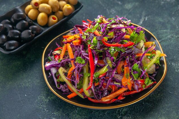 Vooraanzicht heerlijke koolsalade met paprika's in plaat op donkere achtergrond