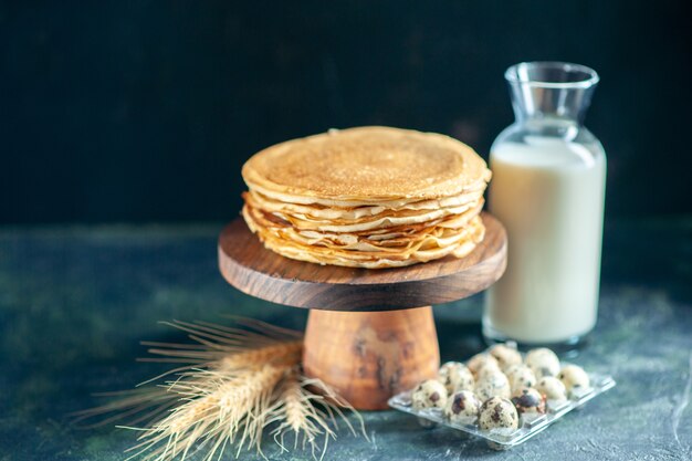 Vooraanzicht heerlijke pannenkoeken op houten bureau en donker ontbijt dessert taart taart zoete melk honing ochtend