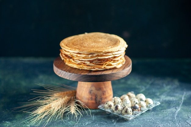 Vooraanzicht heerlijke pannenkoeken op houten bureau en donker ontbijt dessert taart taart zoete melk ochtendthee