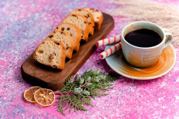 Vooraanzicht heerlijke rozijnencake gesneden taart op roze oppervlak bakken taart suiker zoete koekkoekjes