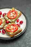 Gratis foto vooraanzicht heerlijke sandwiches met avocado pasta en tomaten in plaat op grijze achtergrond hamburgers sandwich broodje snack brood