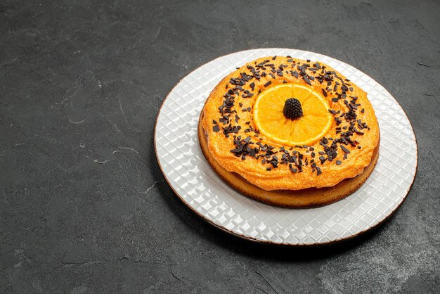 Vooraanzicht heerlijke taart met chocoladeschilfers en stukjes sinaasappel op donkere achtergrond dessert taart taart fruit biscuit