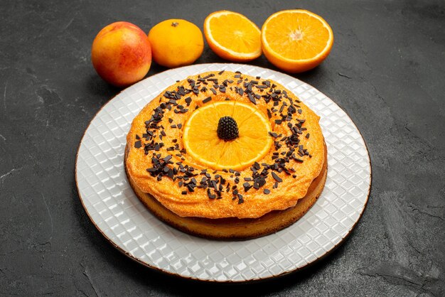 Vooraanzicht heerlijke taart met stukjes sinaasappel op donkere achtergrond fruit dessert taart cake biscuit thee