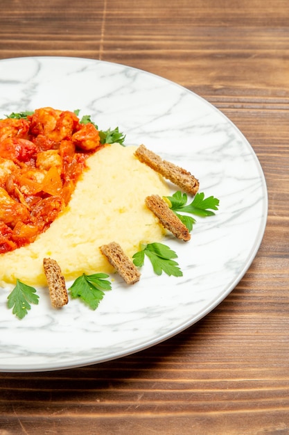 Gratis foto vooraanzicht heerlijke vleesplakken met aardappelpuree en groenten op houten bureau vleesbroodmaaltijd aardappelvoedselschotel