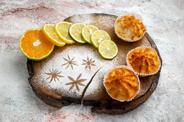 Vooraanzicht heerlijke zoete taarten met plakjes citroen op wit oppervlak koekje zoete bak cake suiker taart cookie