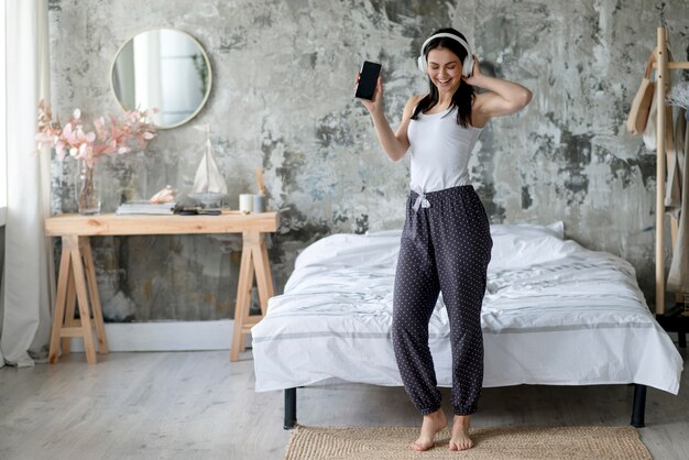 Vooraanzicht het jonge vrouw genieten die aan muziek luisteren