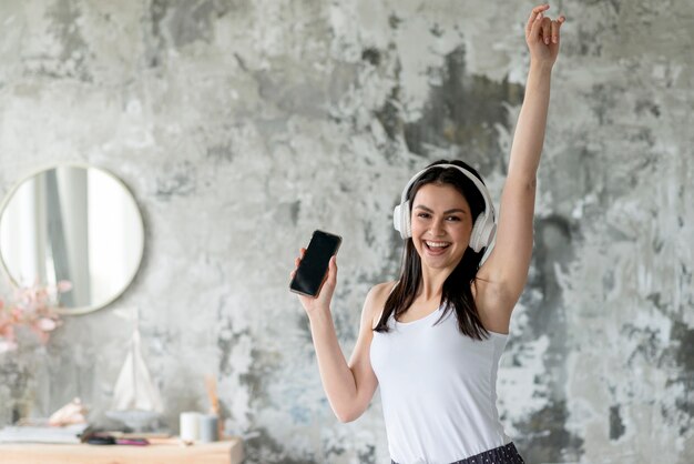 Vooraanzicht het jonge vrouw genieten die aan muziek luisteren