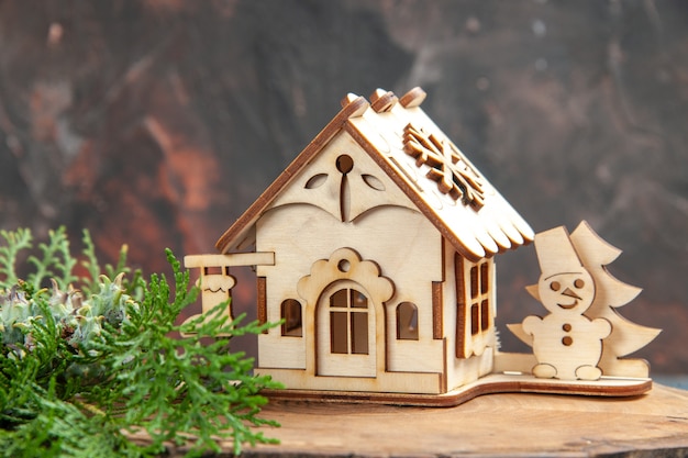 Vooraanzicht houten speelgoed huis dennenboom takken op donkerrode tafel