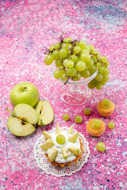 Vooraanzicht in de verte verse groene druiven, geheel zuur en heerlijk fruit met kleine cakes op licht