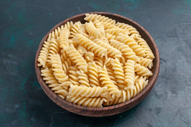 Vooraanzicht Italiaanse pasta heerlijk kijkend in bruine pot op het donkerblauwe bureau