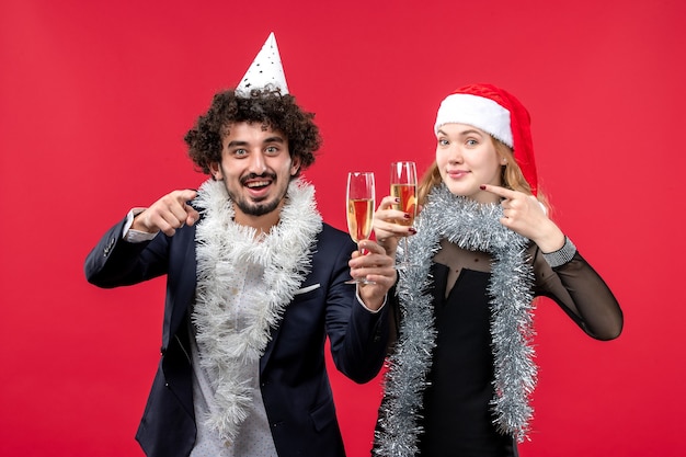 Vooraanzicht jong koppel gelukkig Nieuwjaar vieren op de rode muur foto kerstliefde