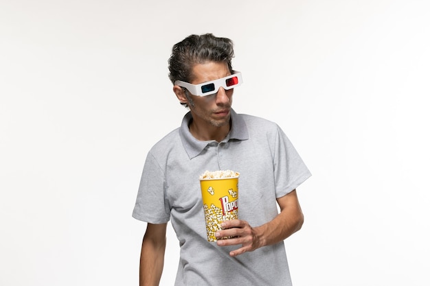 Vooraanzicht jong mannetje met popcornpakket in d zonnebril op het witte oppervlak