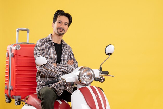 Vooraanzicht jong mannetje op fiets die met zak op geel glimlachen