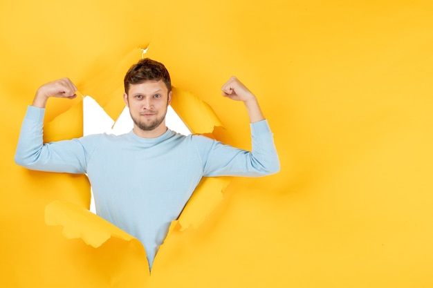 Vooraanzicht jong mannetje op gele gescheurde muur