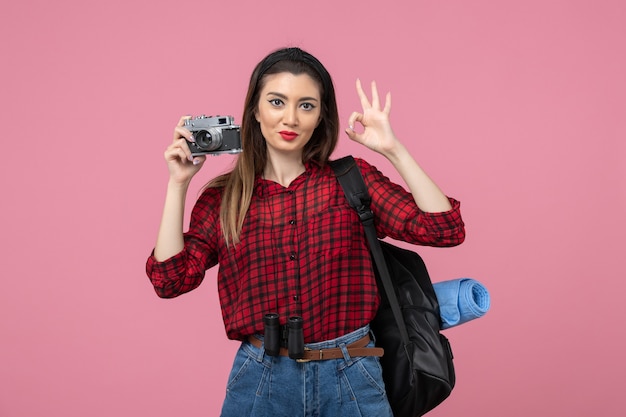 Vooraanzicht jong wijfje dat foto met camera op roze de vrouwenkleur van de bureaufoto neemt