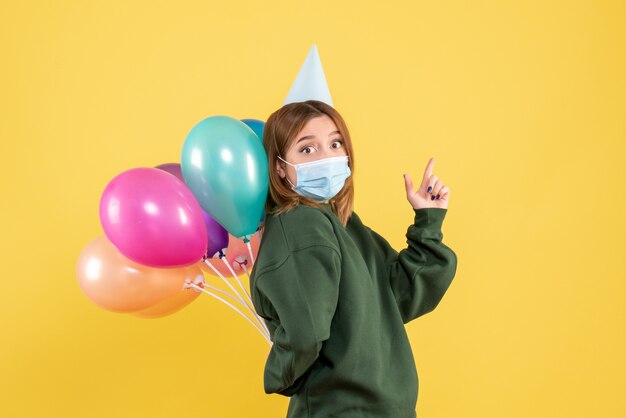 Vooraanzicht jong wijfje dat kleurrijke ballons houdt