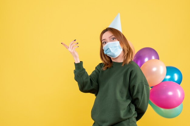 Vooraanzicht jong wijfje dat kleurrijke ballons houdt