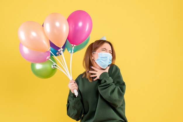 Vooraanzicht jong wijfje dat kleurrijke ballons houdt