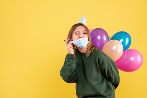 Vooraanzicht jong wijfje dat kleurrijke ballons houdt