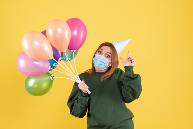 Vooraanzicht jong wijfje dat kleurrijke ballons houdt