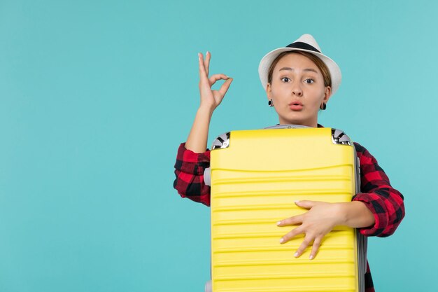 Vooraanzicht jong wijfje dat op vakantie met haar grote zak op blauw bureau gaat