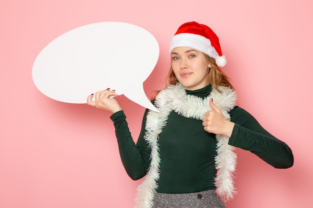 Vooraanzicht jong wijfje die groot wit teken op roze muur houden van Kerstmis nieuwjaar model vakantie kleuren emotie