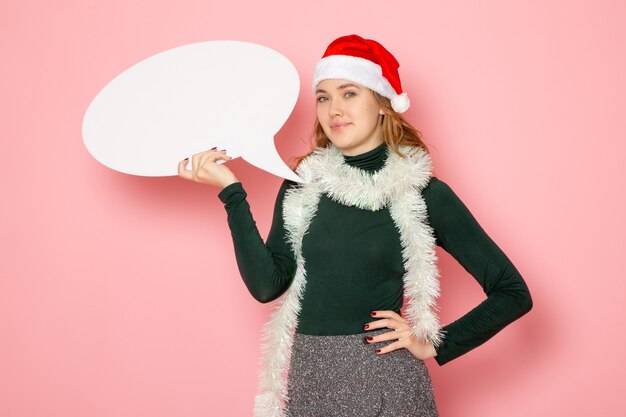 Vooraanzicht jong wijfje die groot wit teken op roze muur houden van Kerstmis nieuwjaar modelvakanties kleur emotie