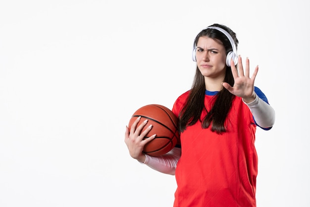 Vooraanzicht jong wijfje in sportkleren met basketbal