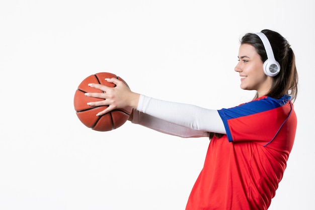 Vooraanzicht jong wijfje in sportkleren met basketbal