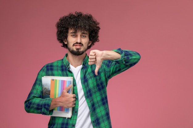 Vooraanzicht jonge kerel houdt niet van sommige notebooks